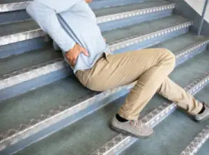 A person in pain on a staircase | Slip and fall accidents