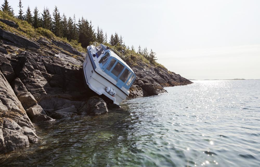 Accident at sea; photo of recreational boat on dry land after collision with rocks. Photographed in Norway, Scandinavia.