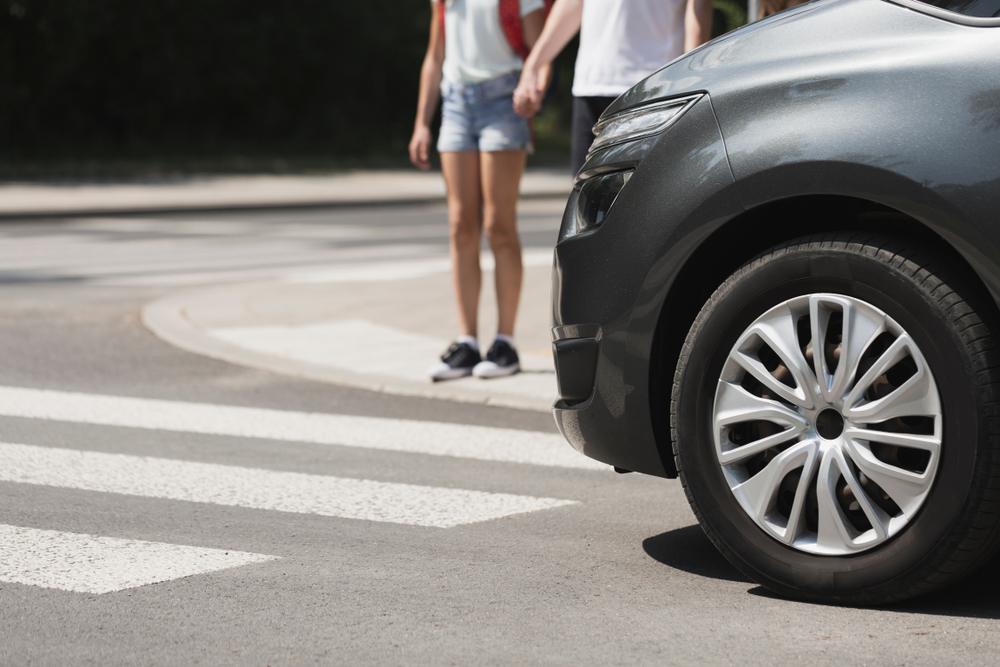 Close-up of a car stopping in front of a pedestrian crossing