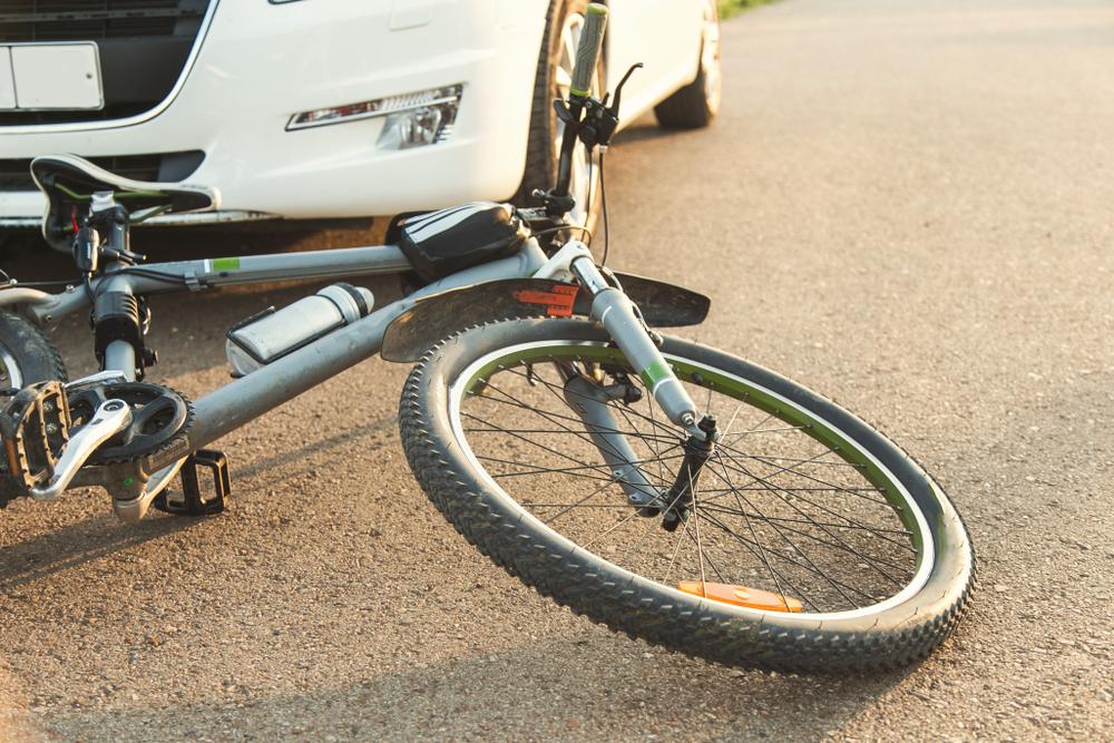 a close-up of a bicycle caught under the wheels of a car. accident on the road, accident, traffic rules